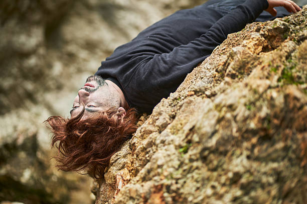 istock Injured hiker lying on a rock after falling from a mountain 2207038610