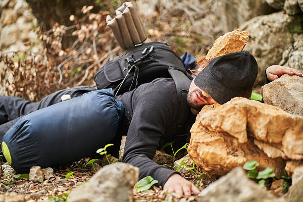 istock Young hiker resting on rocks after mountain accident 2207038698