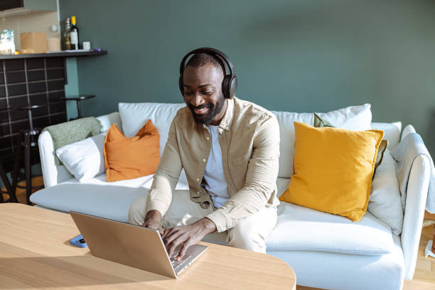 istock Smiling man working on laptop at home 2207039798