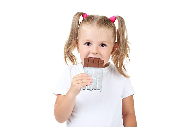 istock Happy little girl eating chocolate on white background 2207043742