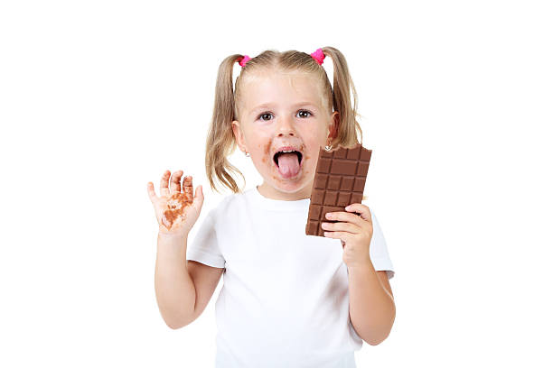 istock Happy little girl eating chocolate on white background 2207043790