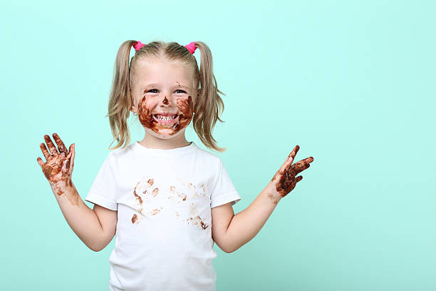 istock Happy little girl in chocolate on mint background 2207044785