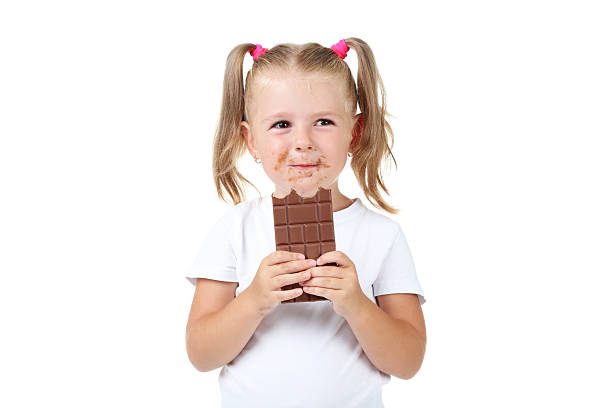 istock Happy little girl eating chocolate on white background 2207045014
