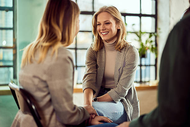 istock Group Therapy Session with Smiling Supportive Individuals in Bright Room 2207047415