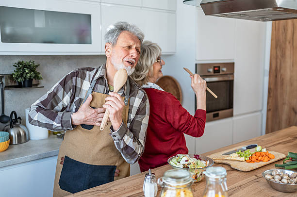 istock Playful senior couple singing in kitchen at home 2207055763