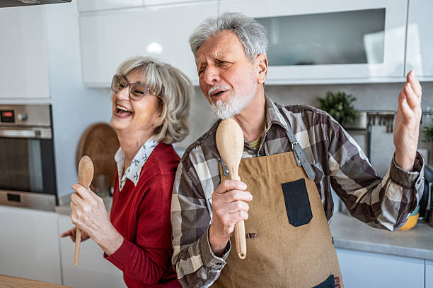 istock Playful senior couple singing in kitchen at home 2207055854