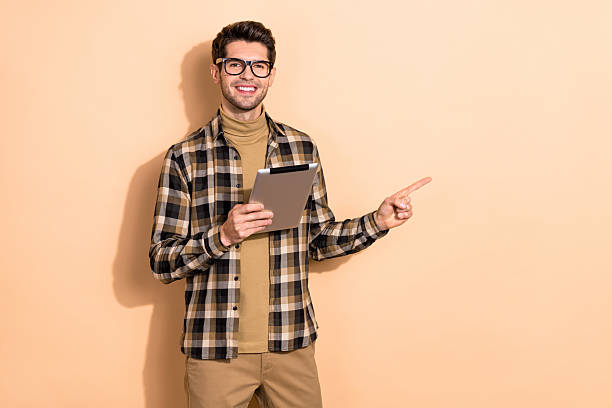 istock Photo of confident representative guy hold tablet point empty space device options isolated pastel color background 2207056808