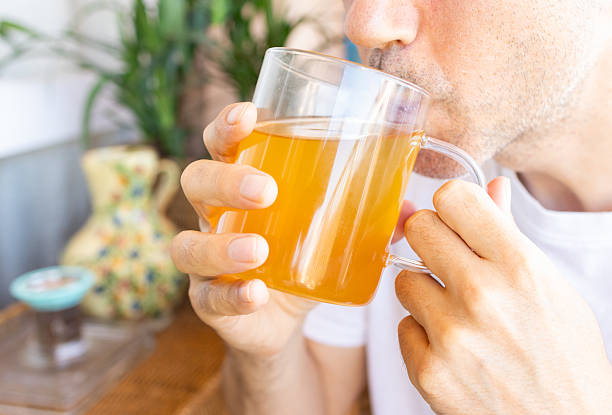 istock unrecognizable Man drinking green tea from glass cup at home 2207058767