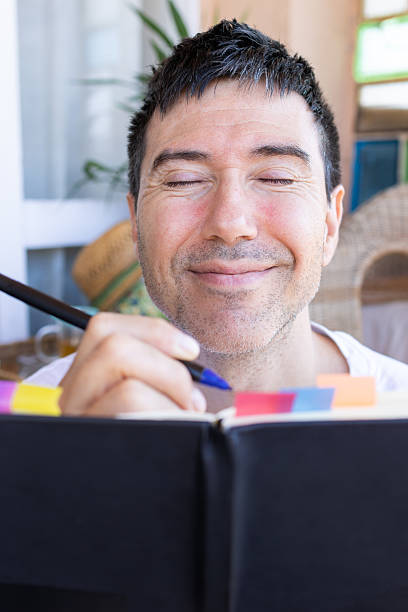 istock Smiling man writing on a journal with closed eyes.mindfulness and wellness. 2207060472
