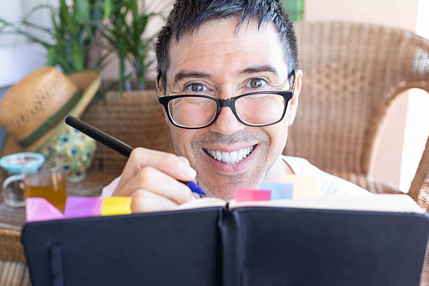 istock Smiling man writing on a journal at home 2207060641
