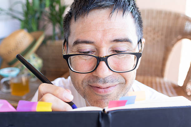 istock Mid adult man writing on a journal at home 2207060696