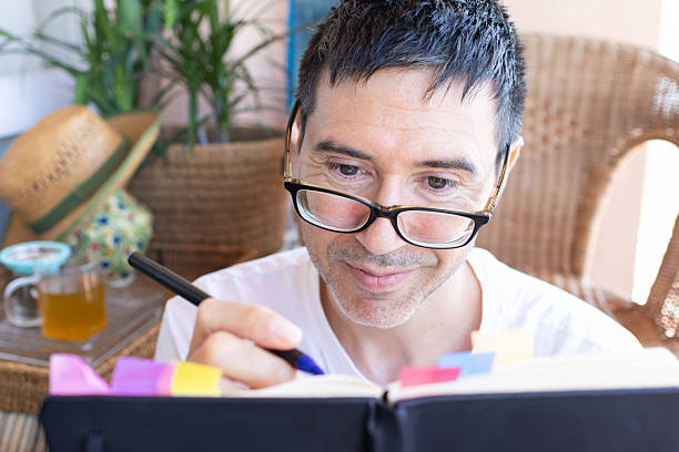 istock Mid adult man writing on a journal at home 2207061085