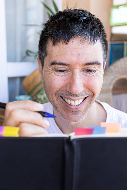 istock Smiling man writing on a journal at home 2207061111