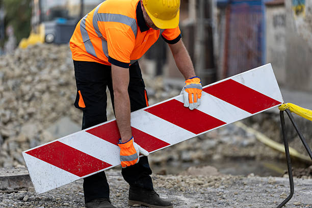 istock Construction worker placing safety barrier at roadwork site during daylight hours in urban setting 2207061772