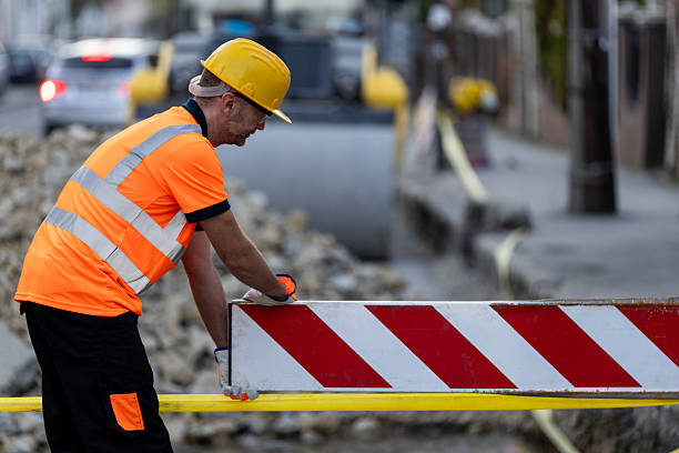 istock Construction worker manages safety barrier in urban setting during daylight hours 2207061847