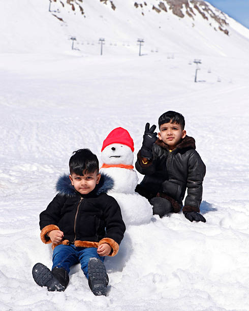 two kids enjoying at snow ski