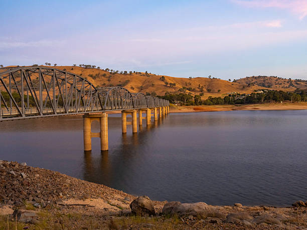 istock Steel truss pylon bridge over lake at sunset 2207064876