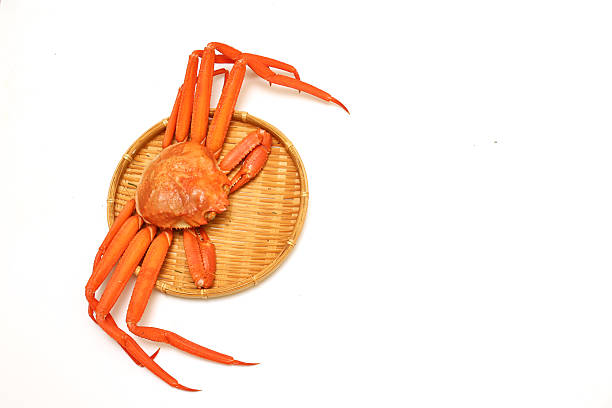On the plate on the table, there is a large cooked crab