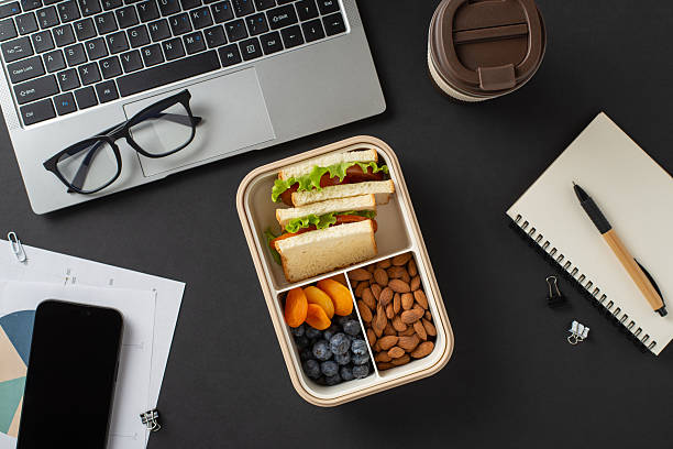 istock A neatly prepared lunchbox with snacks, surrounded by a laptop, notebook, and coffee cup 2207067794