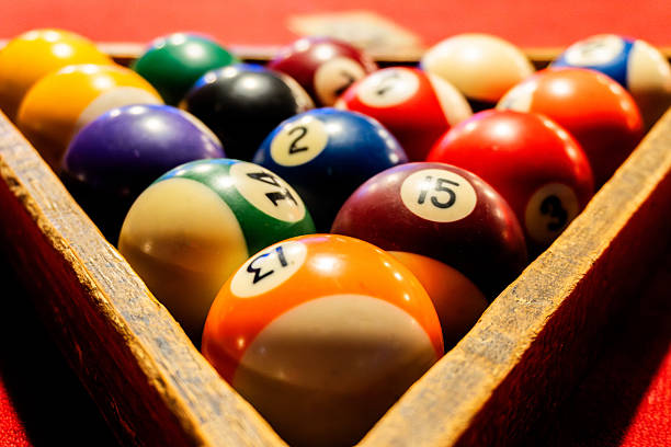 Maroon stripe number fifteen pool ball on a white background, representing the game of billiards. 3D render.