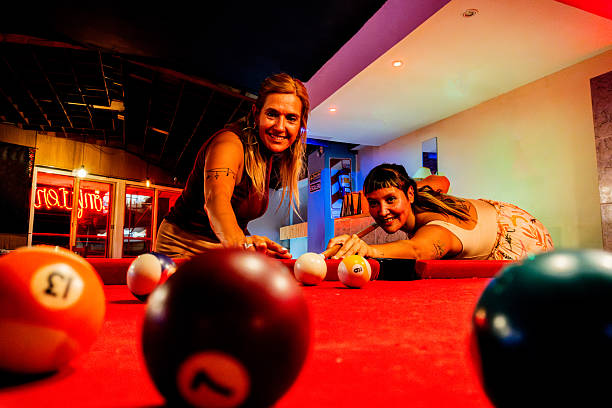 Balls with a cue lie on the green cloth of a billiard table, background.