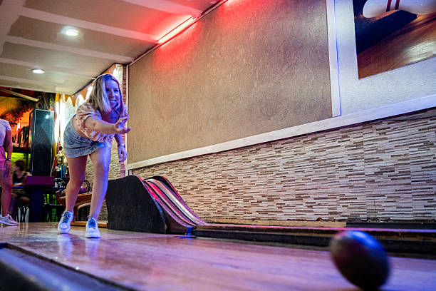 istock Young woman playing bowling at a bowling alley 2207068888