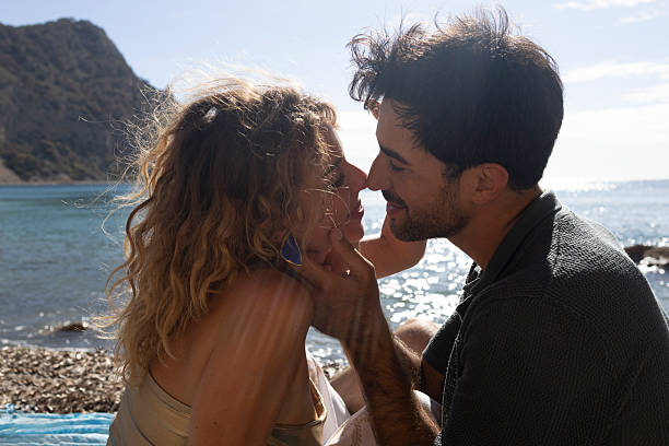 Couple sharing intimate moment at beach on summer day
