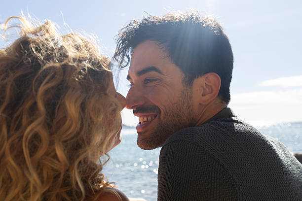istock Happy couple sharing intimate moment at beach on sunny day 2207069707