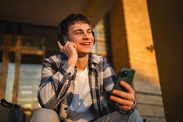istock young man student sit in front university listen music and enjoy 2207073797