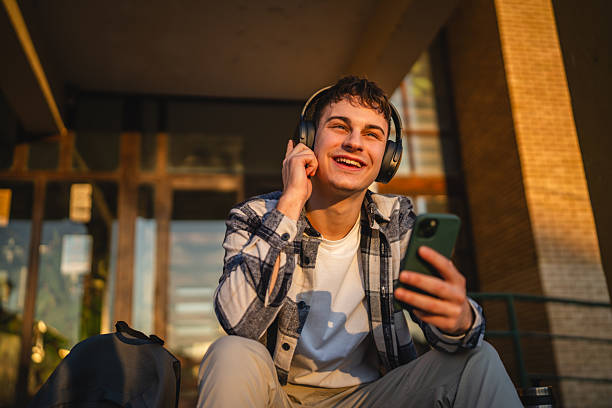 istock young man student sit in front university listen music and enjoy 2207074216