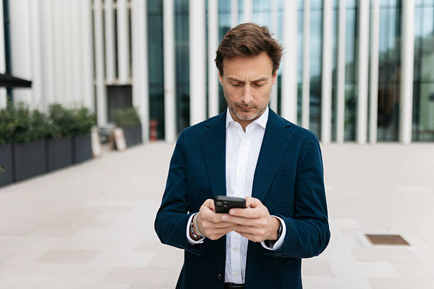 istock Businessman using smartphone outside office building 2207077375