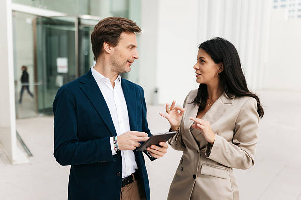 istock Businesspeople using digital tablet and discussing outside office building 2207077751