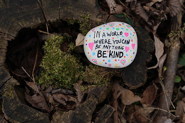istock Moss growing on old forest tree stump with in a world to be anything be kind rock 2207078761