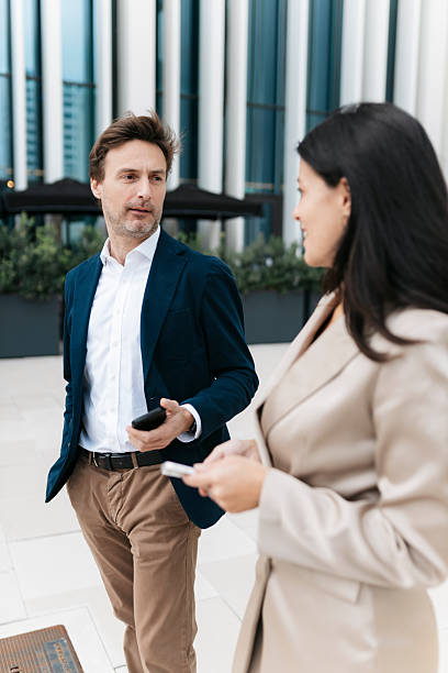 istock Businesspeople discussing while walking outside office building 2207079783