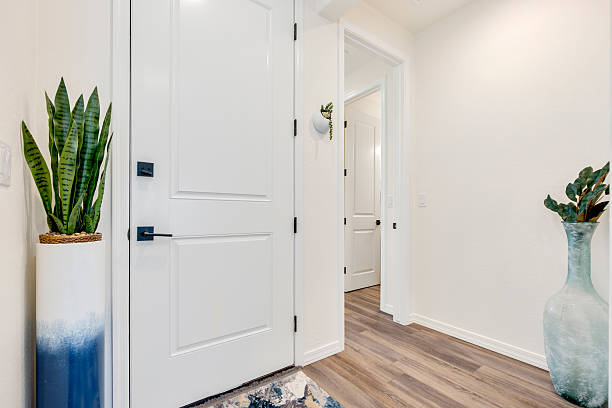 istock The long hallway features a pristine white door and a lovely blue vase 2207084024