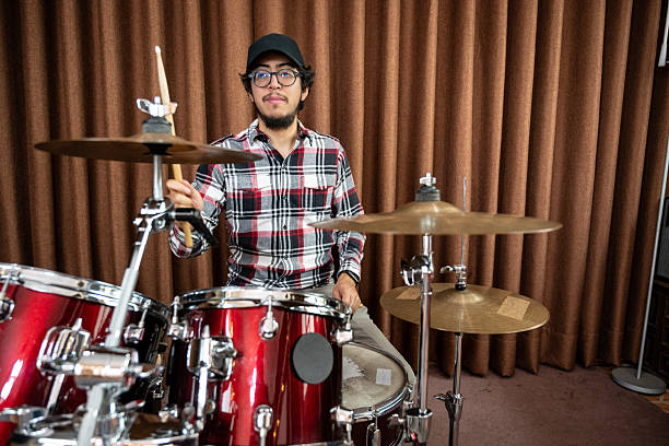 istock Young Male Drummer Playing a Red Drum Set Indoors 2207084552