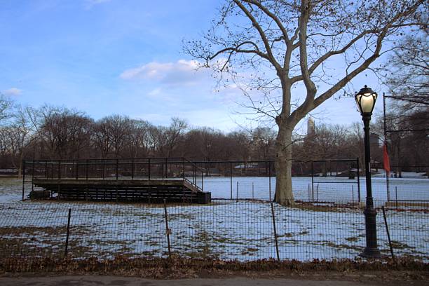 istock Empty baseball field and stands under a thin blanket of snow 2207088801