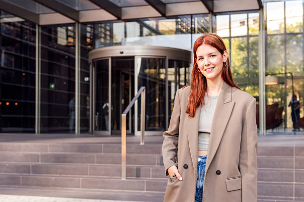 istock smiling young woman in front of office building 2207090409