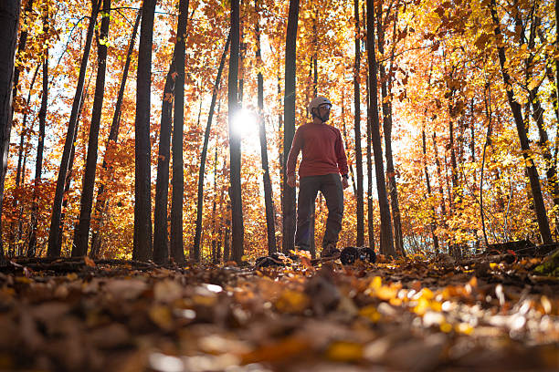 istock Man Rides Electric Mountain Board In Autumn Forest. Sustainability 2207090476