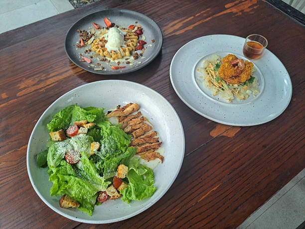 istock Chicken Gladiator Salad With Mix Salad Served, Roasted Chicken, Tomato Cherry, Croutons, Dressing. Yum Som O Or Thai Pomelo Salad With Mango, Cucumber, Pomelo, Breaded Shrimp Served With Som O Dressing. Waffle With Ice Cream, Granola, Strawberry, Almond. 2207091590