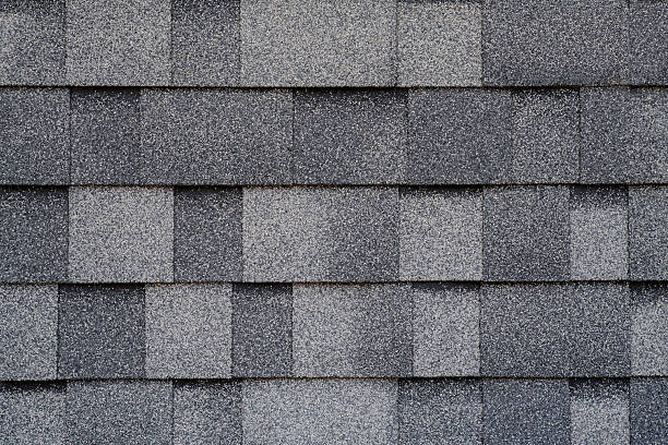 istock Gray asphalt roof tiles, close-up 2207096882