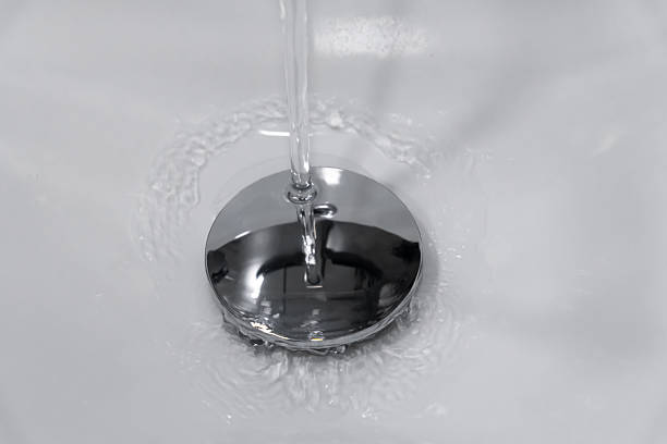 istock Fresh water cascading into a modern chrome sink drain, generating circular ripples and swirling patterns on the surface, reflects cleanliness and purity in a domestic bathroom setting 2207096972