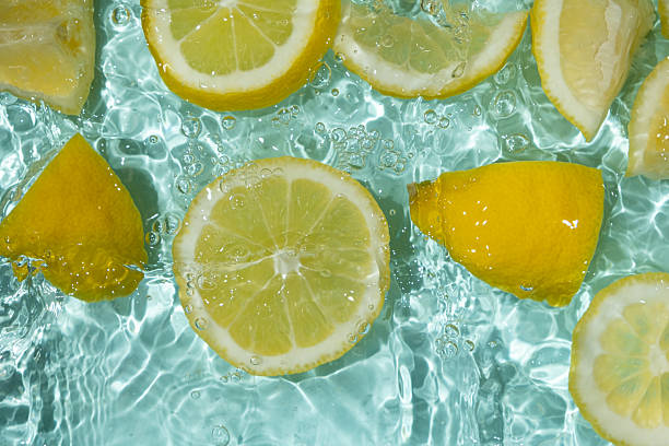 istock Refreshing turquoise citrus background with floating yellow lemon pieces 2207097358