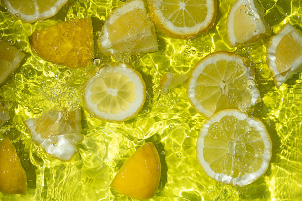 istock Vibrant yellow lemon pieces floating in motion water 2207097402