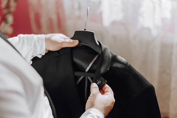istock A man is holding a black jacket and looking at it 2207097998