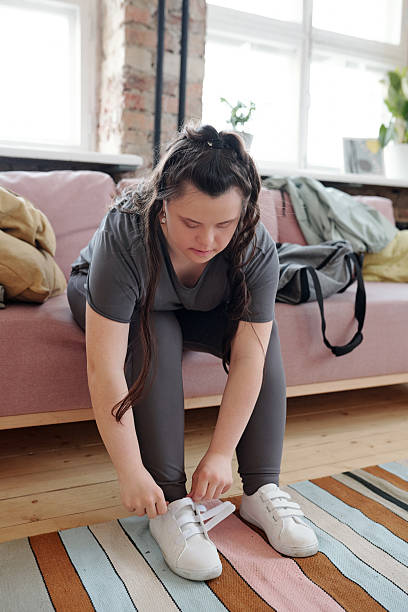 istock Young female in sportswear getting ready for yoga training while sitting on sofa 2207099405