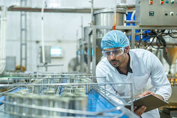 istock Professional closely examining production materials on a conveyor system, representing dedication to quality, precision, and modern technology in manufacturing processes. 2207101016