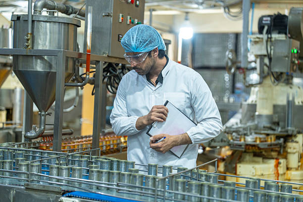 istock A quality control inspector monitors production at an automated food processing plant, using a clipboard for documentation. The scene highlights precision and efficiency in industrial manufacturing. 2207101453