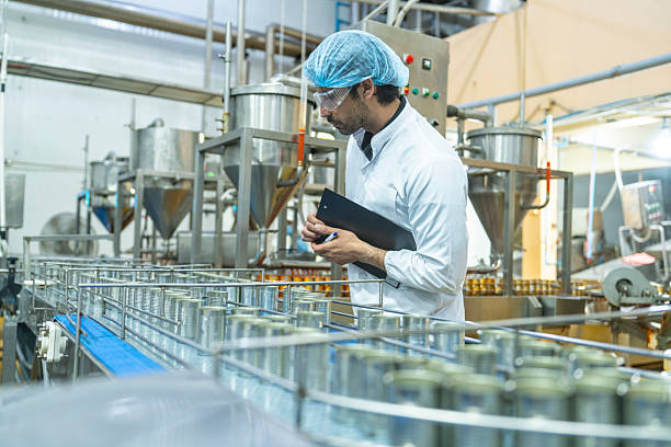 istock Professional closely examining production materials on a conveyor system, representing dedication to quality, precision, and modern technology in manufacturing processes. 2207101651