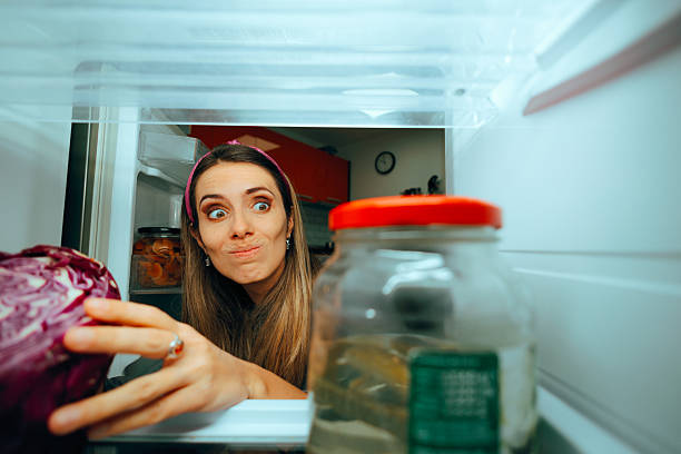 istock Confused Woman Choosing Between Cabbage and Pickled Cucumbers 2207102463